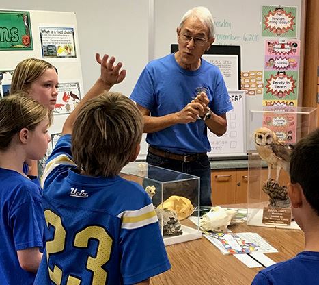 volunteer talks about bird species with school children